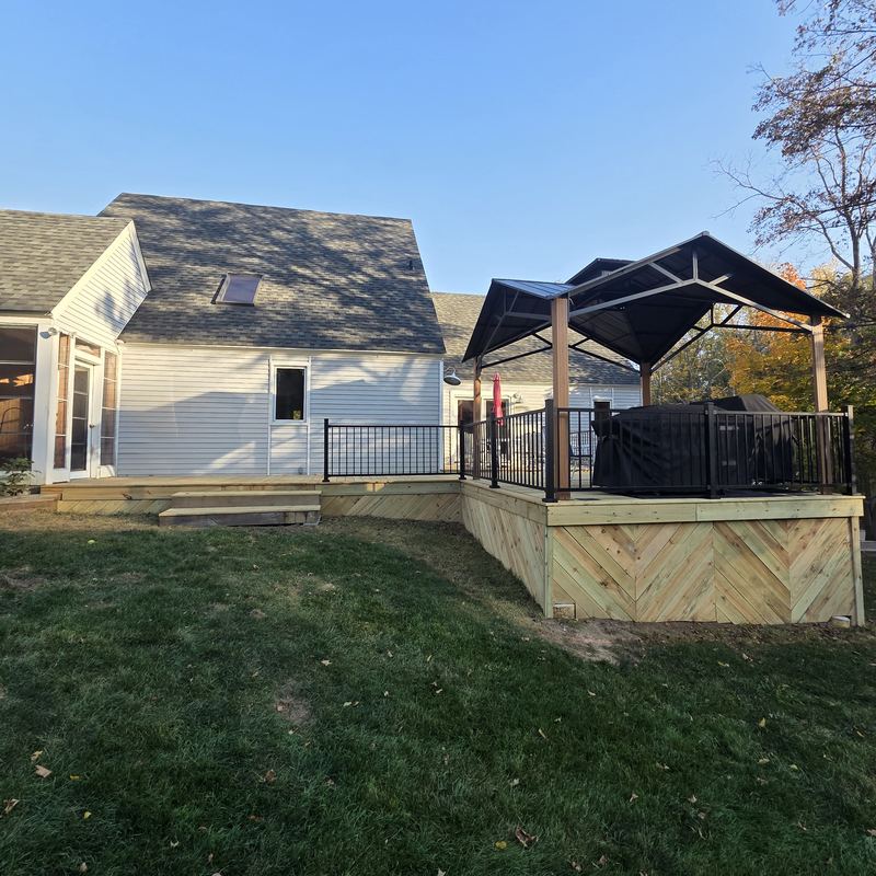 The rebuilt back deck with herringbone skirting, black railings and pergola