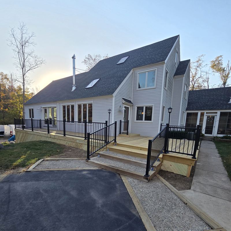 The same front deck rebuilt, with black railings and new steps