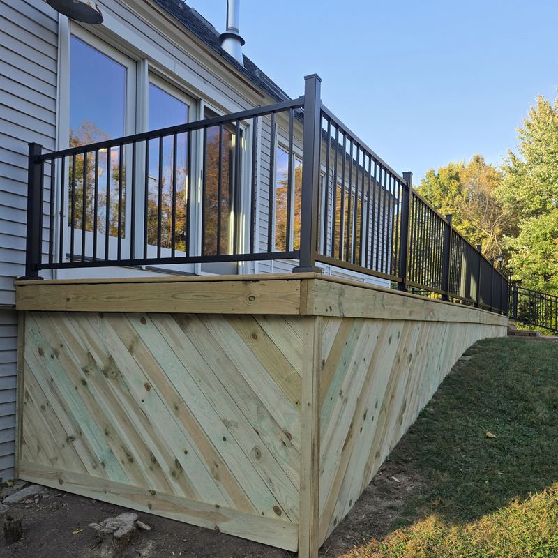 Close-up of diagonal herringbone skirting under a black aluminum railing