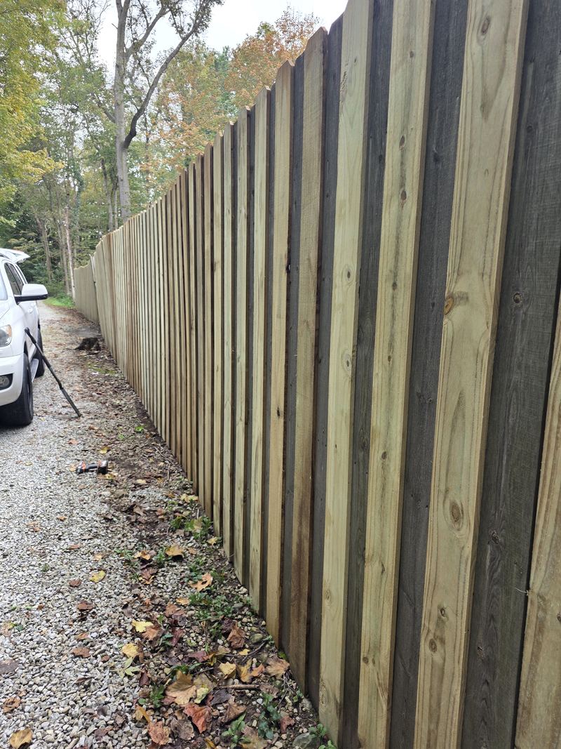 The same fence rebuilt straight with new boards